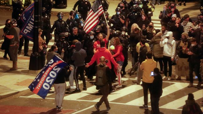 Law enforcement personnel keep an eye as supporters of U.S. President Donald Trump and  supporters of U.S. President-elect Joe Biden exchange words on a street, in Washington